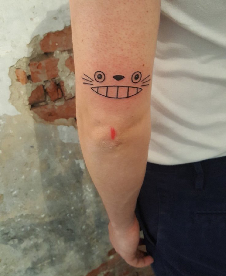 点击大图看下一张：男生手臂上黑色几何简单线条卡通龙猫表情纹身图片