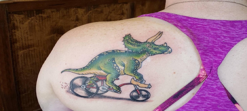 点击大图看下一张：女生后肩上彩绘简单线条自行车和动物恐龙纹身图片