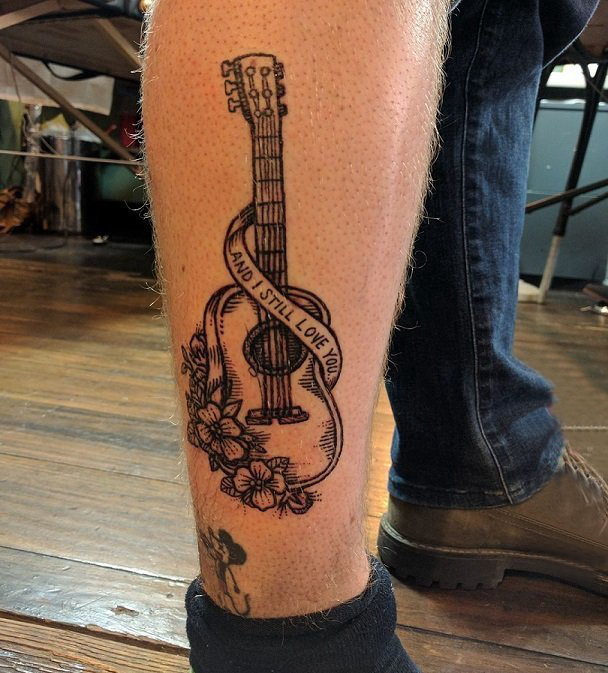 点击大图看下一张：男生小腿上黑色线条文艺精致吉他纹身图片