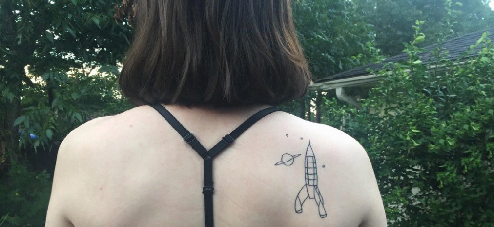 点击大图看下一张：女生后肩上黑色几何简单线条星球和火箭纹身图片