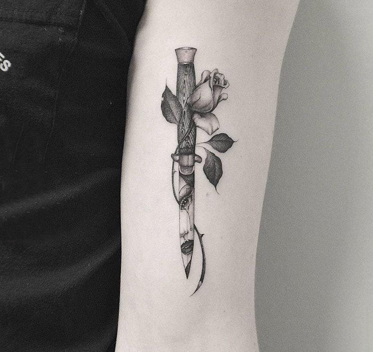 点击大图看下一张：女生手臂上哈哈点刺简单线条植物花朵和匕首纹身图片