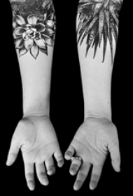 女生手臂上黑色点刺简单线条植物叶子和花朵纹身图片