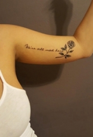 女生手臂上黑色点刺简单线条花体英文和花朵纹身图片