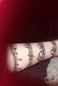 女生手臂上黑色简单抽象线条创意音符纹身图片