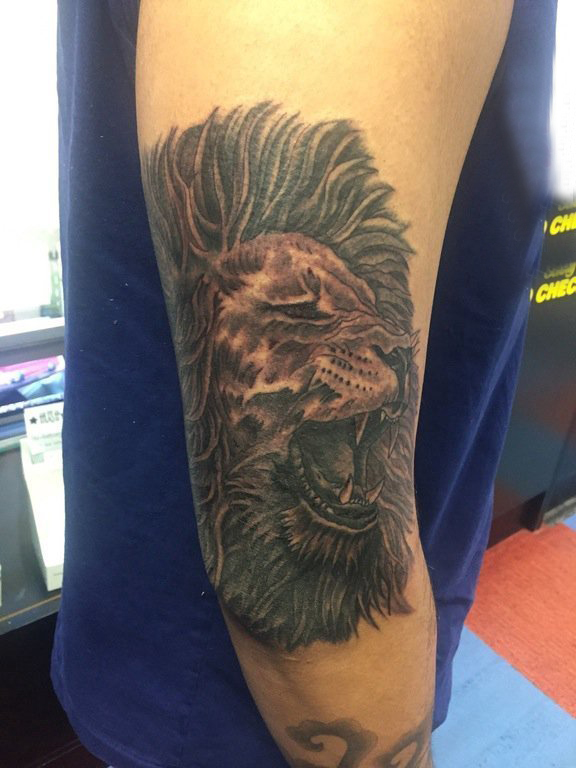 点击大图看下一张：男生手臂上黑灰素描点刺技巧霸气狮子头纹身图片