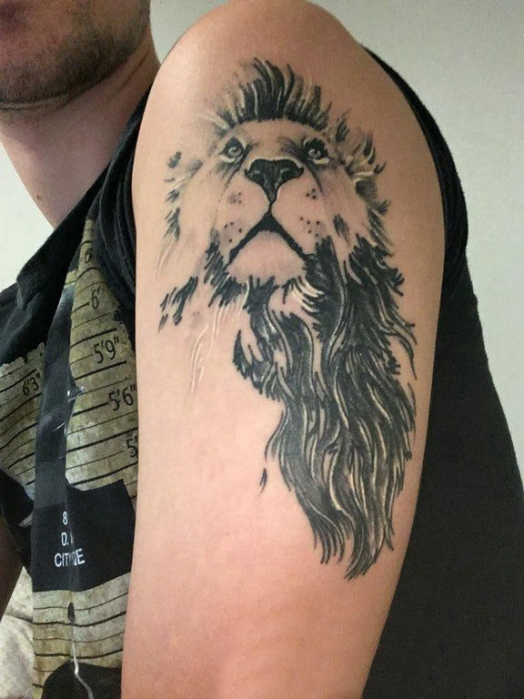 点击大图看下一张：男生大臂上黑色点刺抽象线条小动物狮子纹身图片