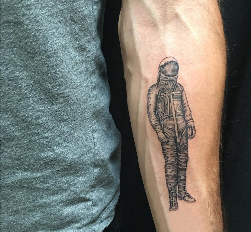 点击大图看下一张：男生手臂上黑灰点刺技巧简单线条人物宇航员纹身图片