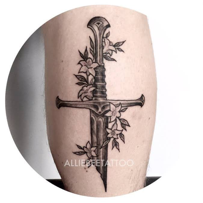 点击大图看下一张：男生小腿上黑色点刺简单线条植物花朵和匕首纹身图片