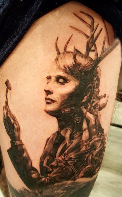 点击大图看下一张：女生大腿上黑灰点刺简单线条鹿角和人物肖像纹身图片