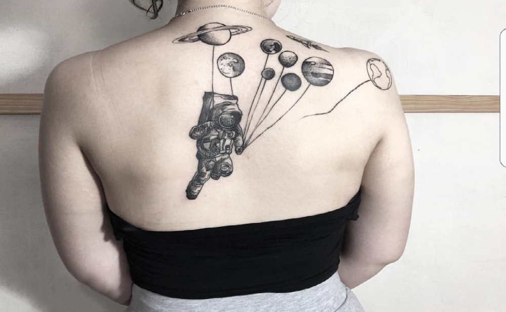 点击大图看下一张：女生后背上黑色点刺几何简单线条星球和宇航员纹身图片