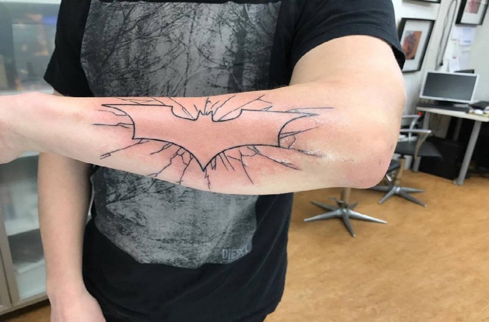 点击大图看下一张：蝙蝠侠标志纹身男生手臂上黑色的蝙蝠侠标志纹身图片