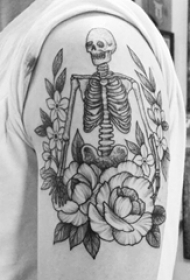 男生大臂上黑灰点刺简单线条花朵和骷髅骨架纹身图片