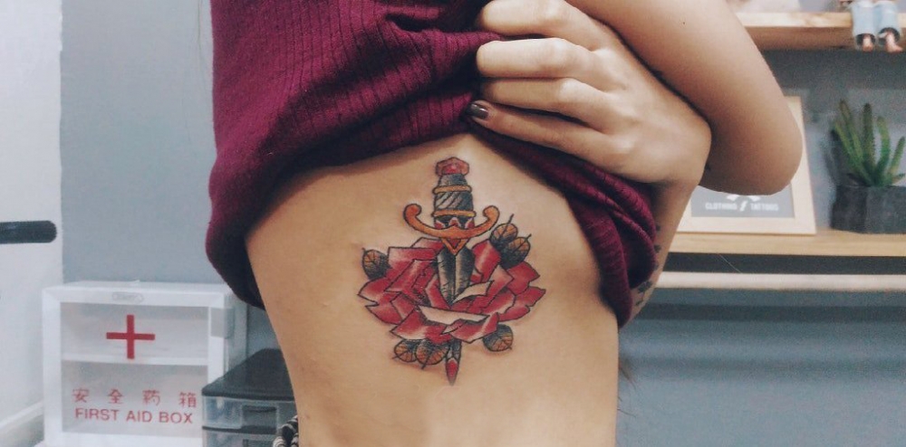 点击大图看下一张：花朵纹身 女生侧腰上花朵和匕首纹身图片
