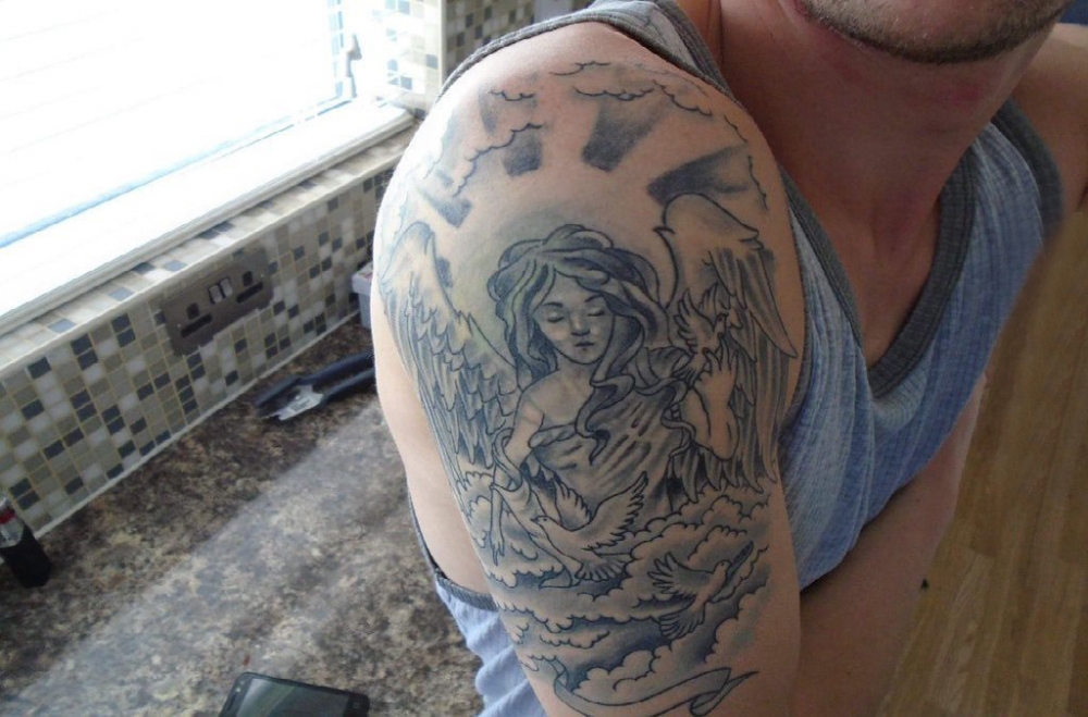 点击大图看下一张：纹身守护天使 男生大臂上黑色的天寺纹身图片