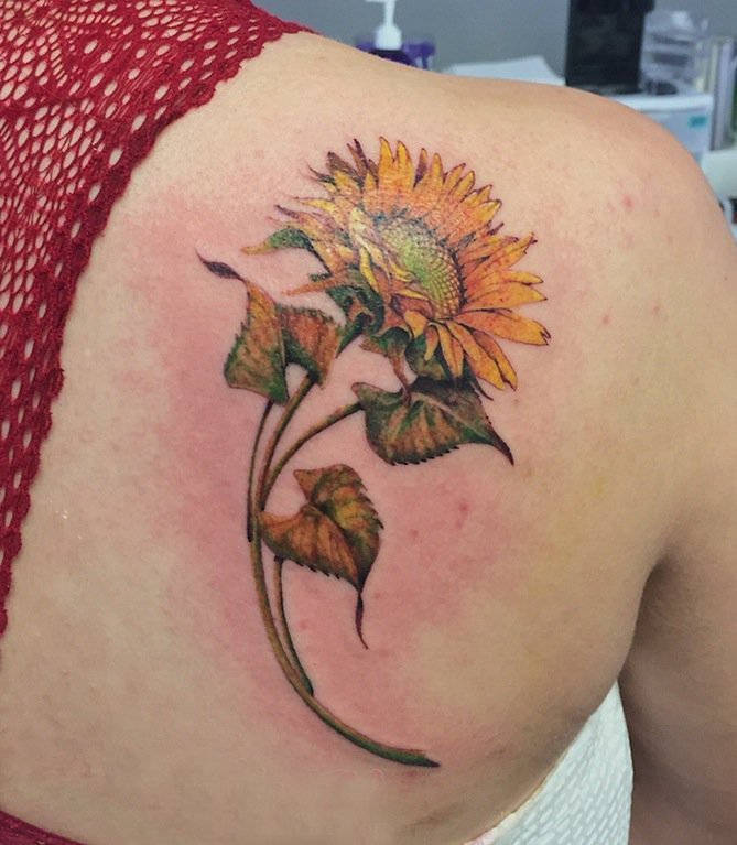 点击大图看下一张：向日葵纹身图片 女生后背上彩色的向日葵纹身图片