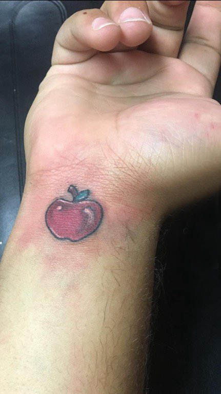 点击大图看下一张：苹果图案纹身 男生手腕上彩色的苹果纹身图片