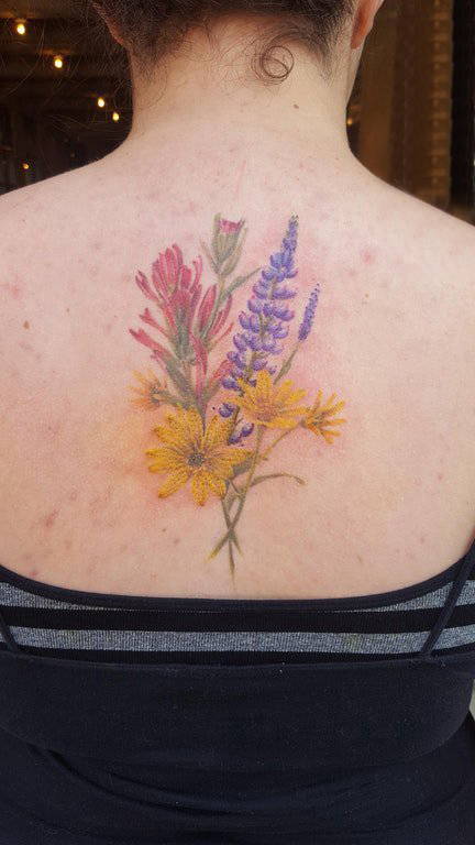 点击大图看下一张：纹身小花朵 女生后背上彩色的花朵纹身图片