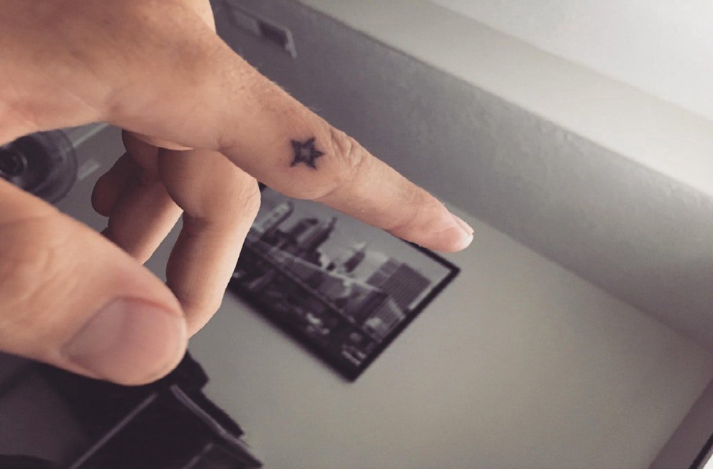 点击大图看下一张：大五角星纹身 男生手指上黑色的五角星纹身图片