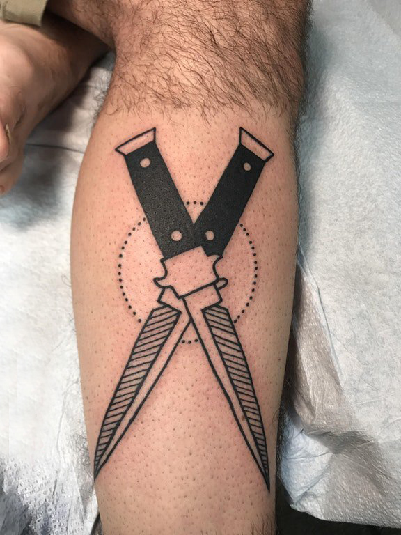 点击大图看下一张：欧美匕首纹身 男生小腿上黑色的匕首纹身图片