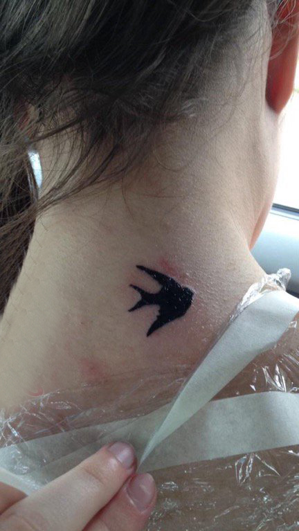 点击大图看下一张：纹身燕子 女生颈后黑色的燕子纹身图片