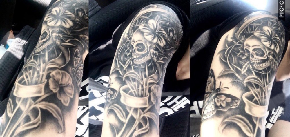 点击大图看下一张：骷髅花朵纹身图案 男生手臂上黑色纹身骷髅花朵纹身图案