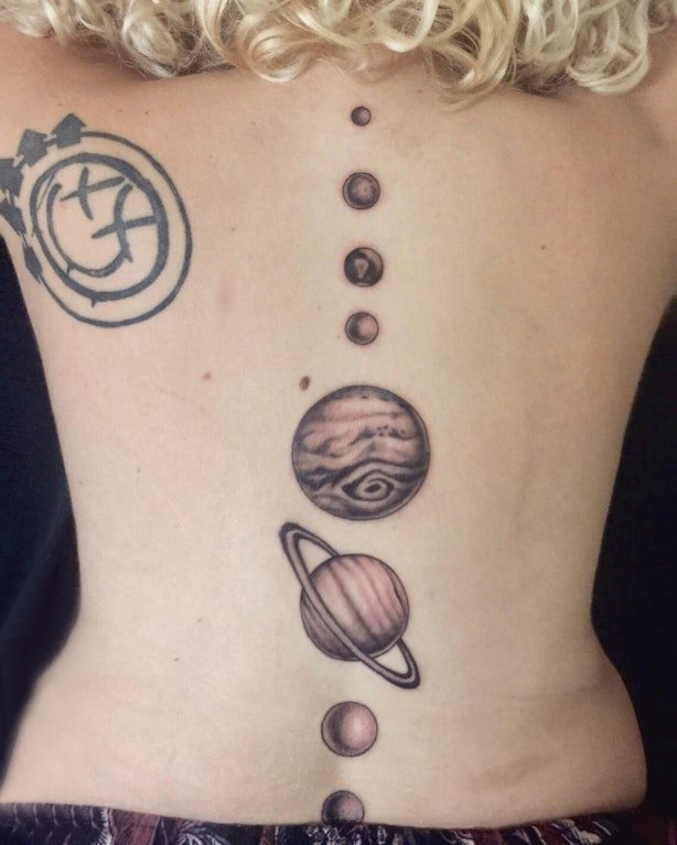 点击大图看下一张：脊柱纹身图案 女生后背上黑色的星球纹身图片