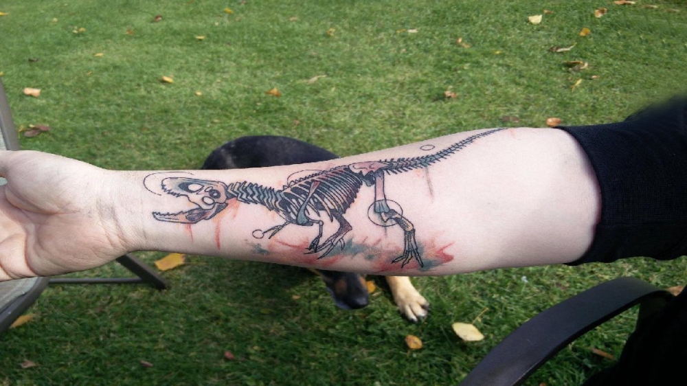 点击大图看下一张：德国恐龙纹身 男生手臂上彩色的恐龙骨头纹身图片