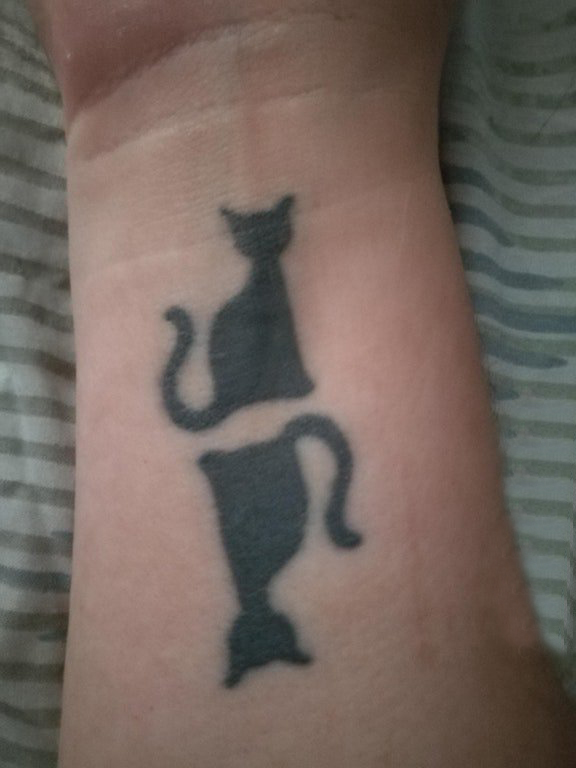 点击大图看下一张：纹身手腕宠物 女生手腕上黑色的猫咪纹身图片