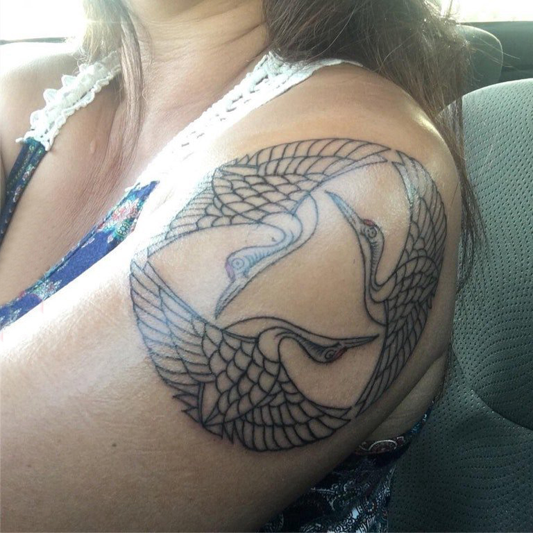 点击大图看下一张：仙鹤纹身 女生大臂上黑色的仙鹤纹身图片