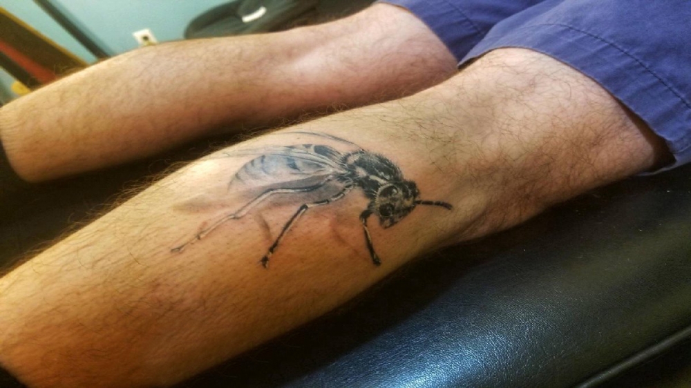 点击大图看下一张：小动物纹身 男生小腿上黑色的蜜蜂纹身图片