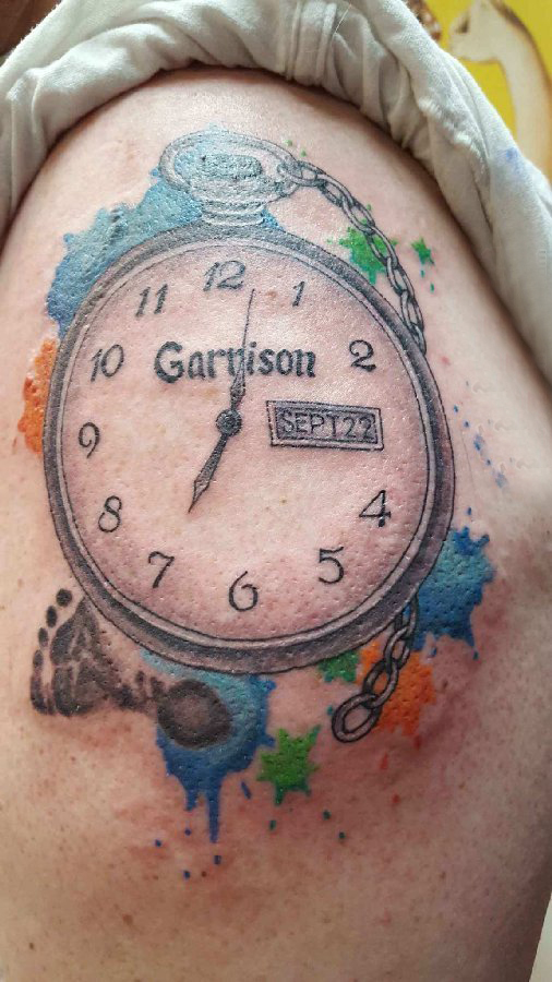 点击大图看下一张：时钟纹身 男生大臂上彩色的时钟纹身图片