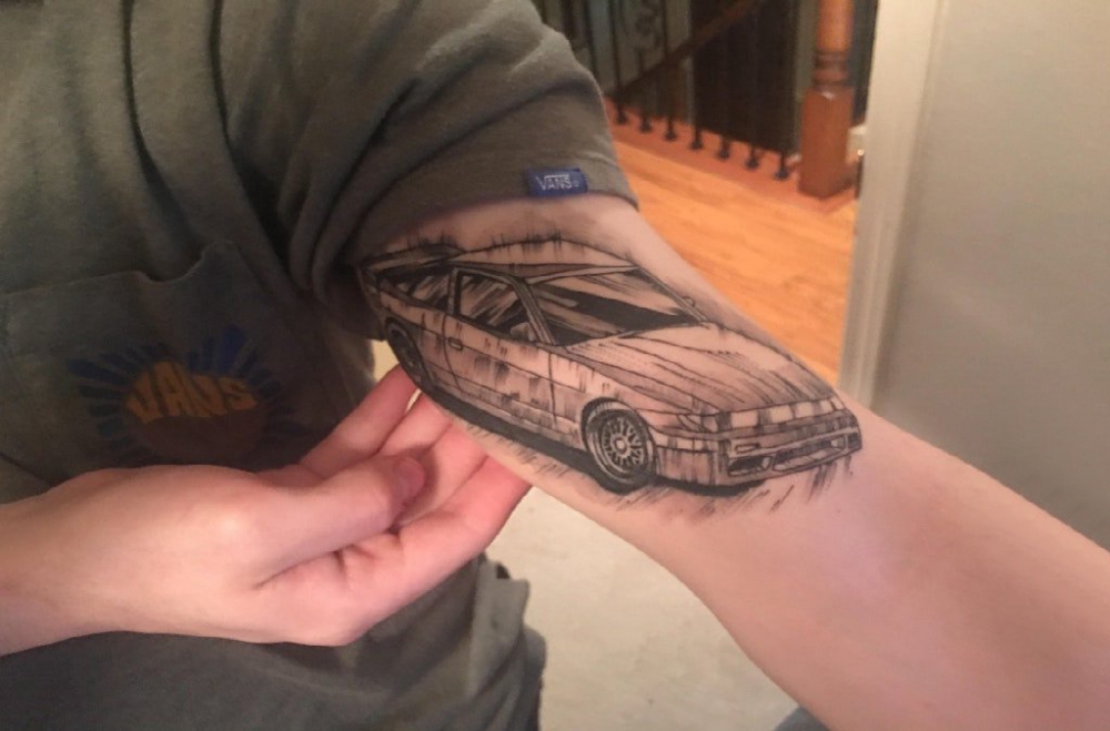 点击大图看下一张：汽车纹身 男生大臂上黑色的汽车纹身图片