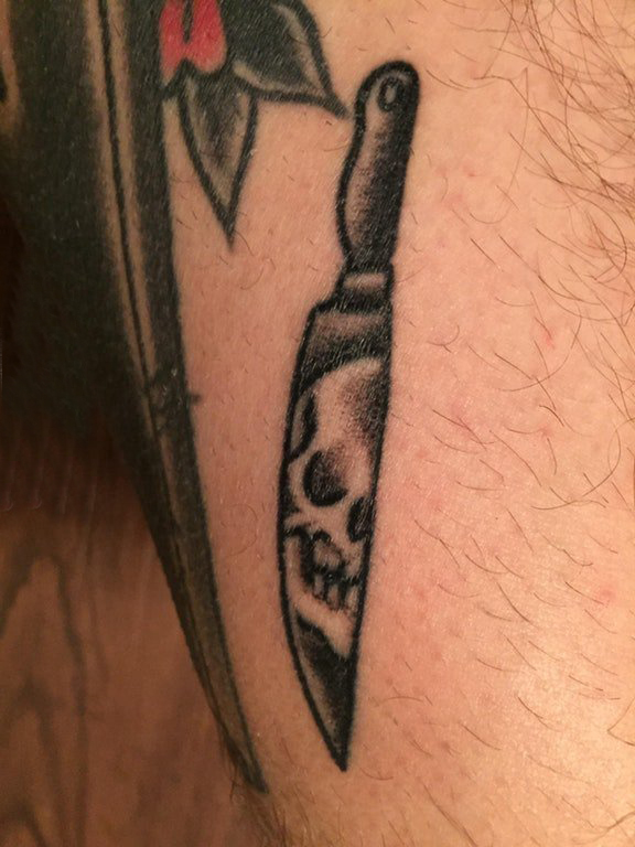 点击大图看下一张：用刀纹身 男生大腿上黑色的骷髅刀纹身图片
