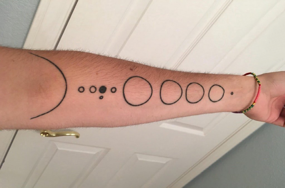 点击大图看下一张：几何元素纹身 男生手臂上黑色的圆形纹身图片