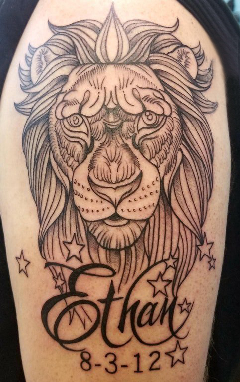 点击大图看下一张：百乐动物纹身 男生大臂上英文和狮子纹身图片