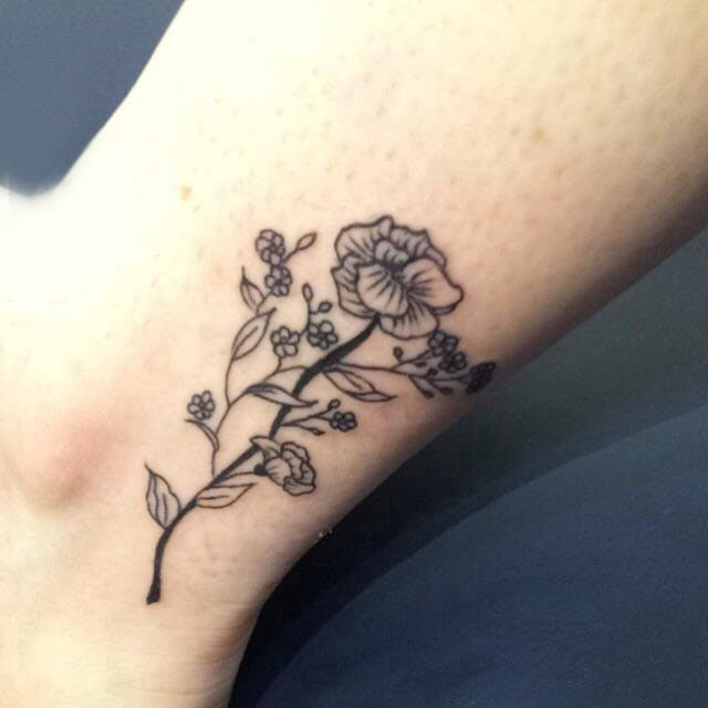 点击大图看下一张：植物纹身 女生小腿上黑色的花朵纹身图片
