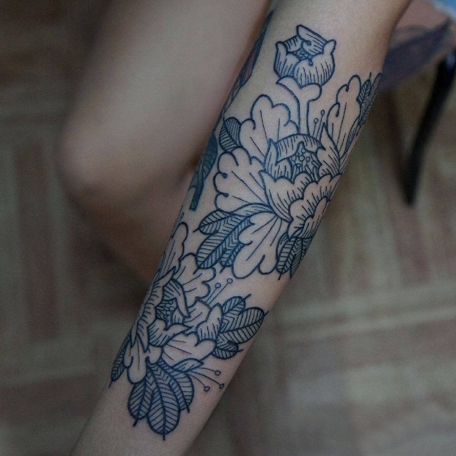 点击大图看下一张：植物纹身素材 女生手臂上黑色的花朵纹身图片