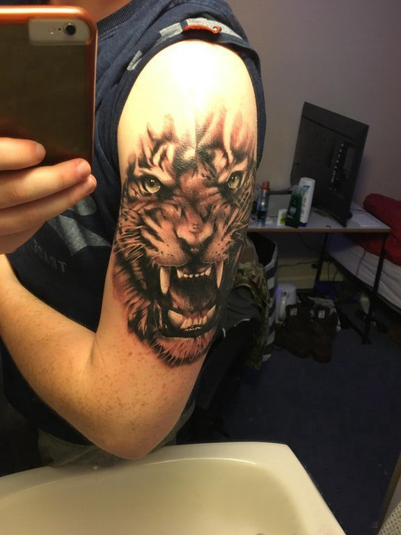 点击大图看下一张：纹身点刺技巧 男生大臂上黑色的老虎纹身图片