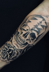 骷髅花朵纹身图案 男生手臂上黑色的花朵和骷髅纹身图片