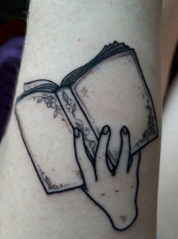 点击大图看下一张：几何元素纹身 女生手臂上手部和书籍纹身图片
