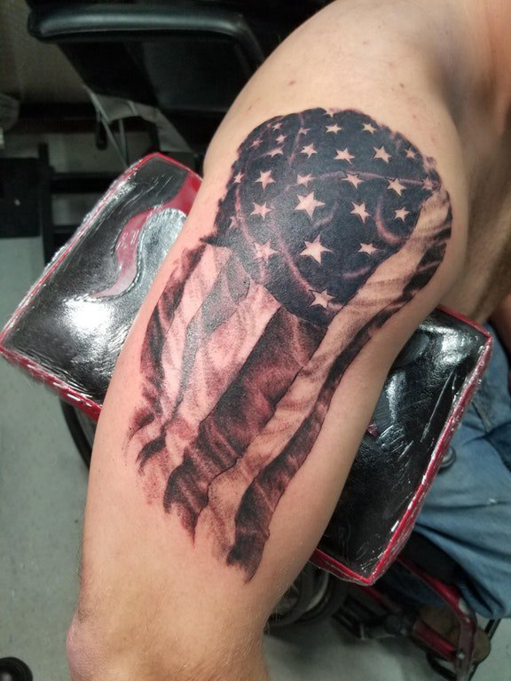 点击大图看下一张：双大臂纹身 男生大臂上黑色的国旗纹身图片