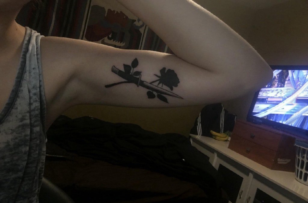 点击大图看下一张：双大臂纹身 女生大臂上匕首和花朵纹身图片