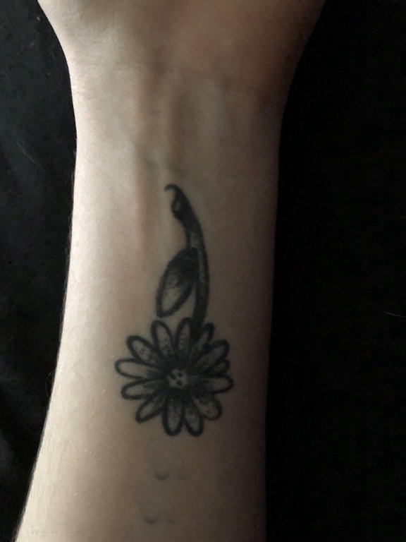 点击大图看下一张：女生纹身手腕 女生手腕上黑上的花朵纹身图片