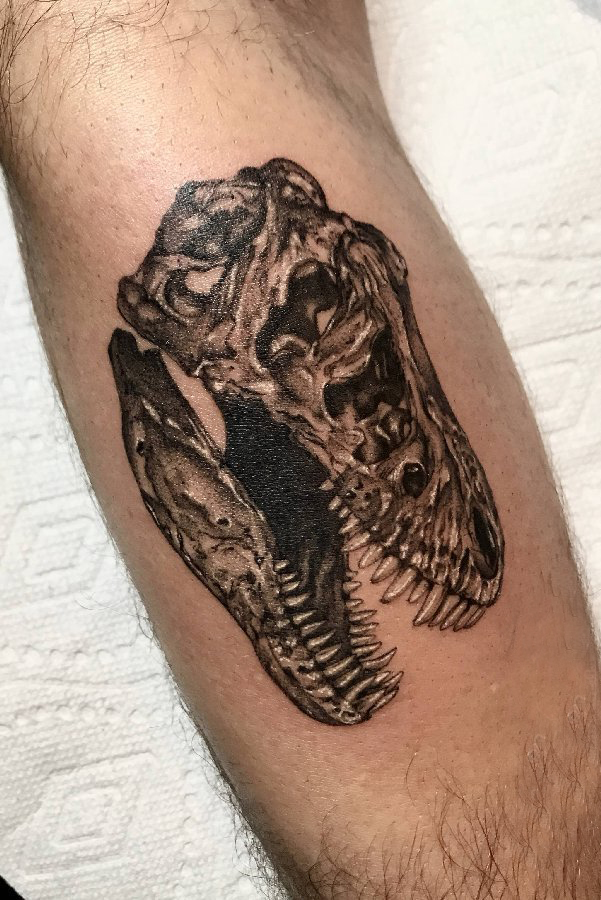 点击大图看下一张：欧美小腿纹身 男生小腿上黑色的恐龙头骨纹身图片