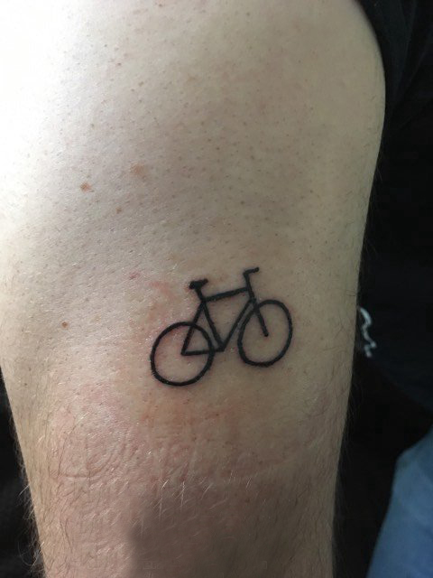 点击大图看下一张：几何元素纹身 男生大臂上黑色的自行车纹身图片