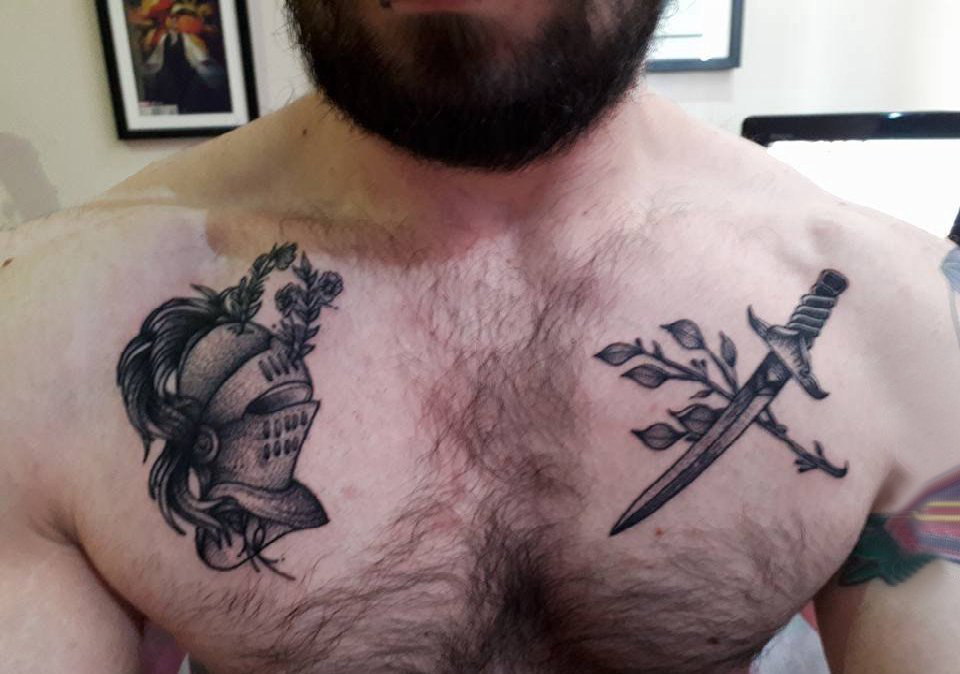 点击大图看下一张：胸部纹身男 男生胸部长剑和头盔纹身图片