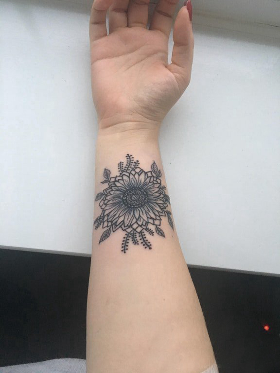 点击大图看下一张：黑灰写实纹身 女生手腕上黑色的花朵纹身图片