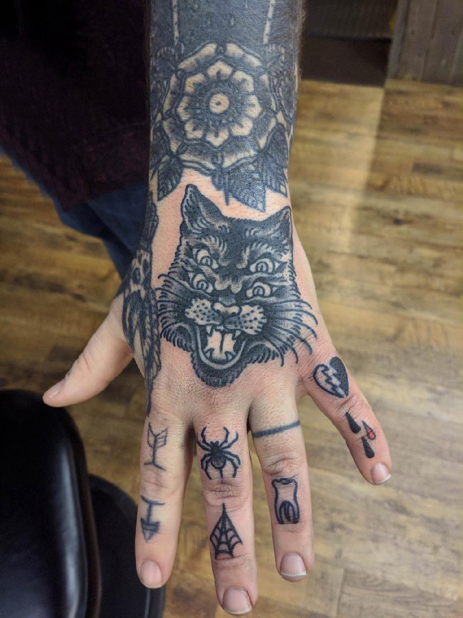 点击大图看下一张：手背纹身 男生手臂上黑色的猫咪纹身图片