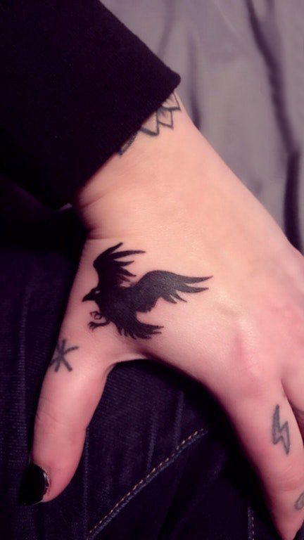 点击大图看下一张：女生虎口纹身图案 女生手背上黑色的乌鸦纹身图片
