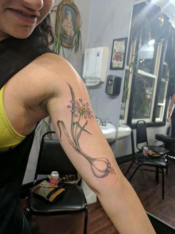 点击大图看下一张：水仙花纹身图案  女生大臂上黑灰的水仙花纹身图片